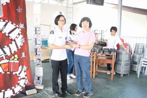 The organizing chairlady was giving souvenir to the teacher advisor.