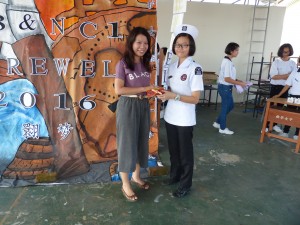 The organising chairlady was giving the souvenir to the teacher advisor,